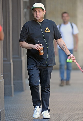 Jonah Hill in jeans and white adidas sneakers on the street