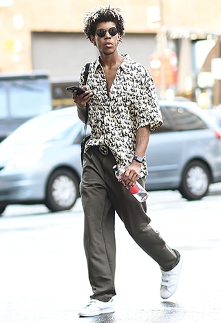 New York Fashion Week street styler wearing a dropped down khaki overalls and a graphic tee | ASOS Style Feed