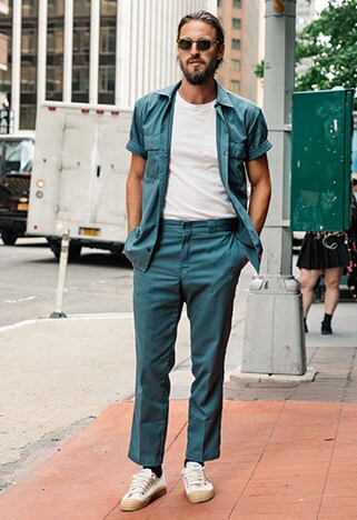 New York Fashion Week street styler wearing a dropped down khaki overalls and a graphic tee | ASOS Style Feed
