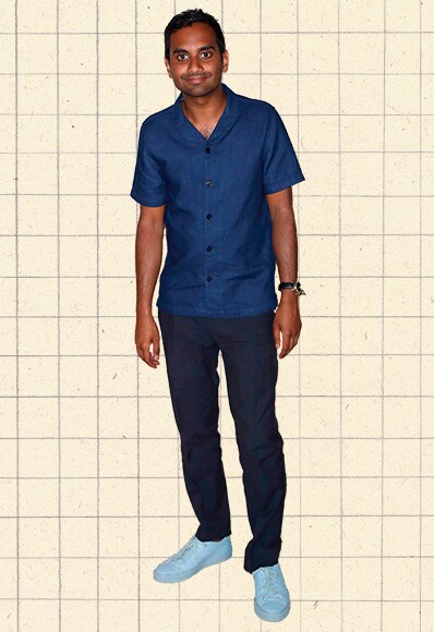 Aziz Ansari wearing a navy, short-sleeved, revere-collared shirt, linen trousers and sky-blue sneakers | ASOS Style Feed