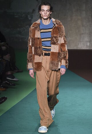 Catwalk model wearing baggy brown trousers, a blue and yellow striped jumper and patchwork jacket | ASOS Style Feed 