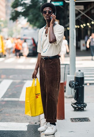 Street-styler wearing brown cord trousers, open polo shirt and white sneakers | ASOS Style Feed