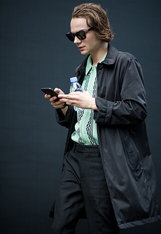 Street-styler wearing a green, patterned knitted polo with a black windbreaker | ASOS Style Feed