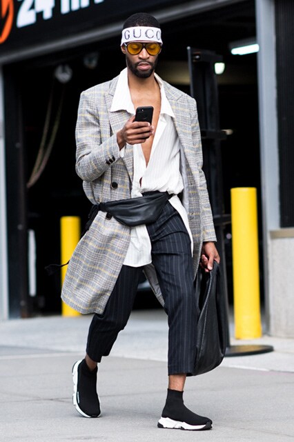 New York Fashion Week street-styler wearing an open white shirt, check overcoat, pinstripe trouser and Balenciaga trainers | ASOS Style Feed