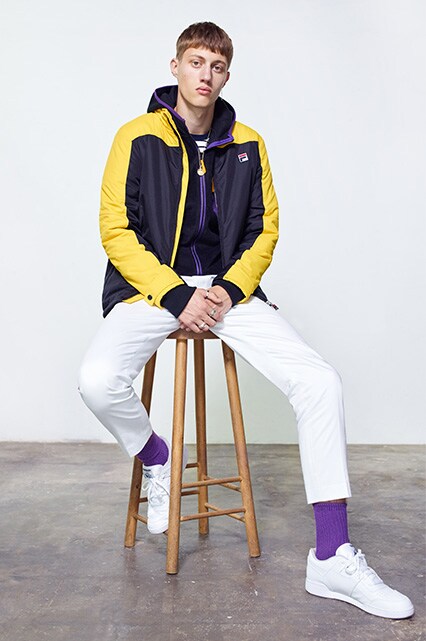 Model wearing a FIla windcheater, white chinos, purple socks and white trainers | ASOS Style Feed