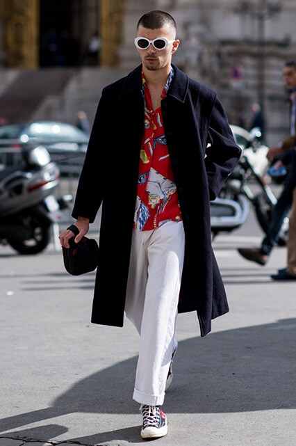 PFW SS18 Street Style featuring a street styler in a patterned shirt, white trousers, navy overcoat and oval-shaped sunglasses | ASOS Style Feed