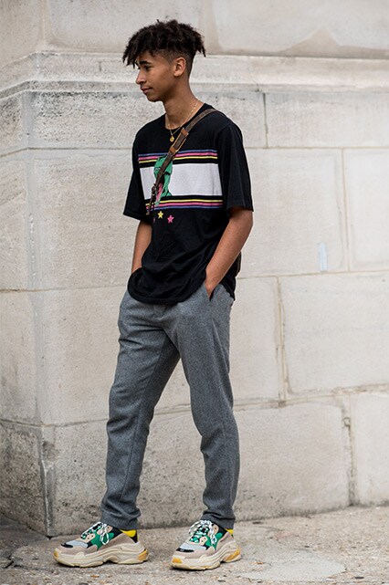 PFW SS18 Street Style featuring a street styler in a graphic-print T-shirt, grey slacks, a cross-body bag and Balenciaga Triple S trainers | ASOS Style Feed