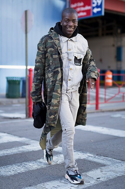 A street-styler wearing a denim jacket and trousers, a camo coat and chunky trainers | ASOS Style Feed
