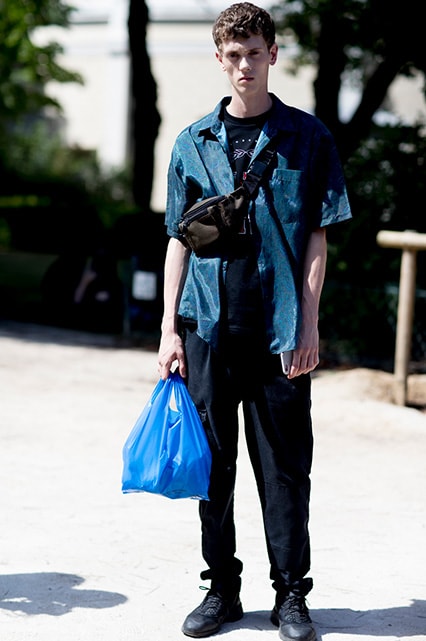 A street-styler wearing a graphic-print T-shirt, short-sleeved shirt, cargo trousers and a khaki bum bag | ASOS Style Feed