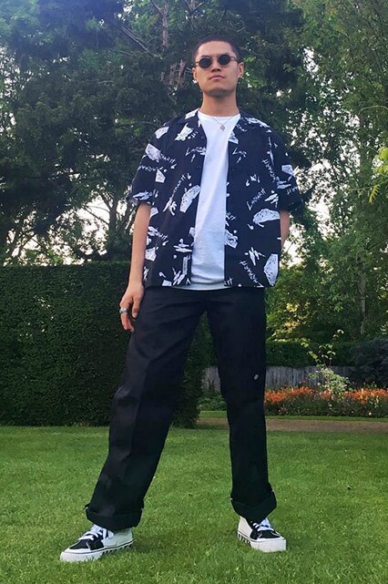 ASOS Insider Nawal wearing a white T-shirt, black graphic-print short-sleeved shirt, black cargo trousers, Vans trainers and sunglasses | ASOS Style Feed