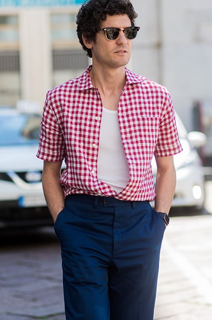 A street-styler wearing a white vest, check shirt, sunglasses and navy chinos | ASOS Style Feed