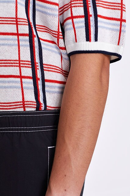 A model wearing a check polo shirt, shorts, socks and sandals available at ASOS | ASOS Style Feed