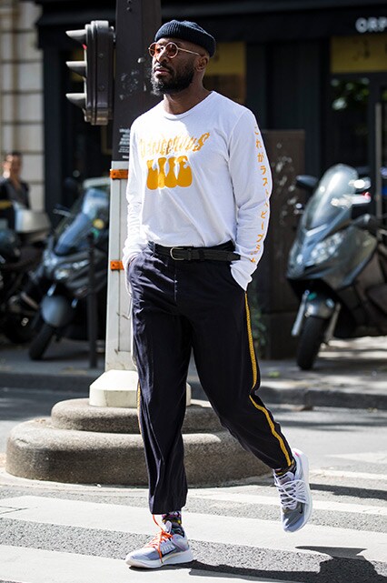A street styler at Paris Fashion Week Men's SS19 wearing a long-sleeved top, beanie, sunglasses and tracksuit bottoms | ASOS Style Feed