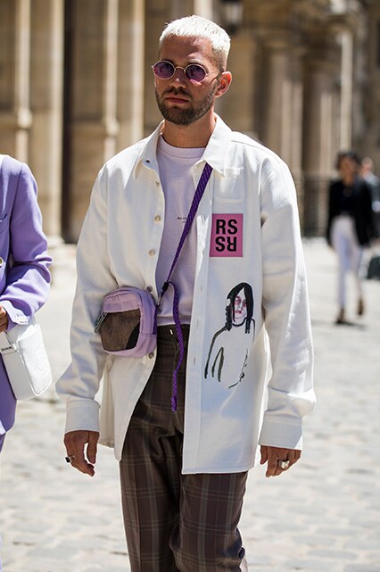 A street styler at Paris Fashion Week Men's SS19 wearing a lilac T-shirt, shacket, brown check trousers, cross-body bag and purple shades | ASOS Style Feed