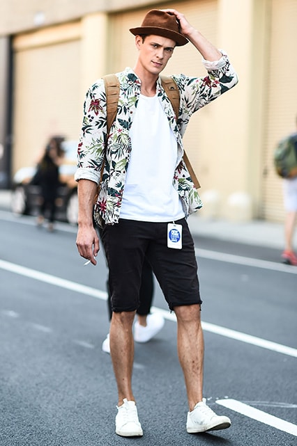 A street-styler wearing a T-shirt, printed shirt and denim shorts | ASOS Style Feed