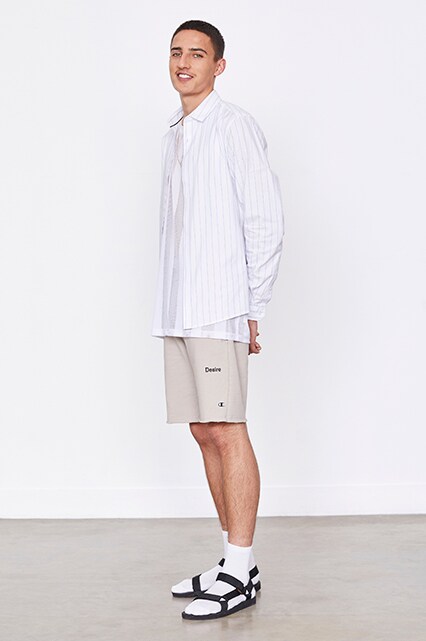 An ASOS model in a white T-shirt, striped shirt, shorts and socks and sandals | ASOS Style Feed