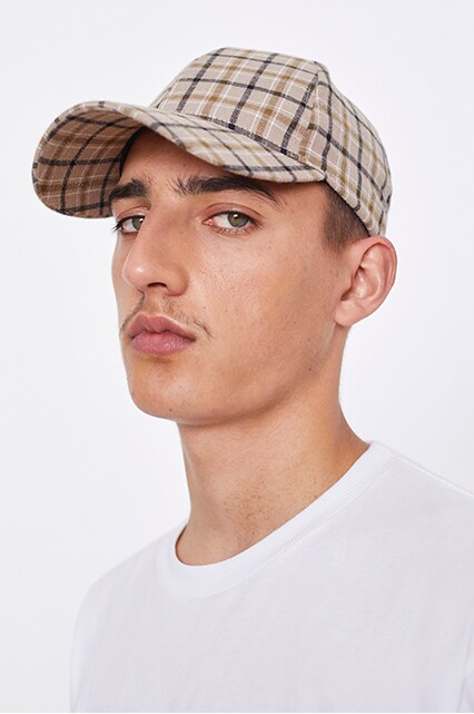 An ASOS model wearing a check cap and a Carhartt WIP top | ASOS Style Feed