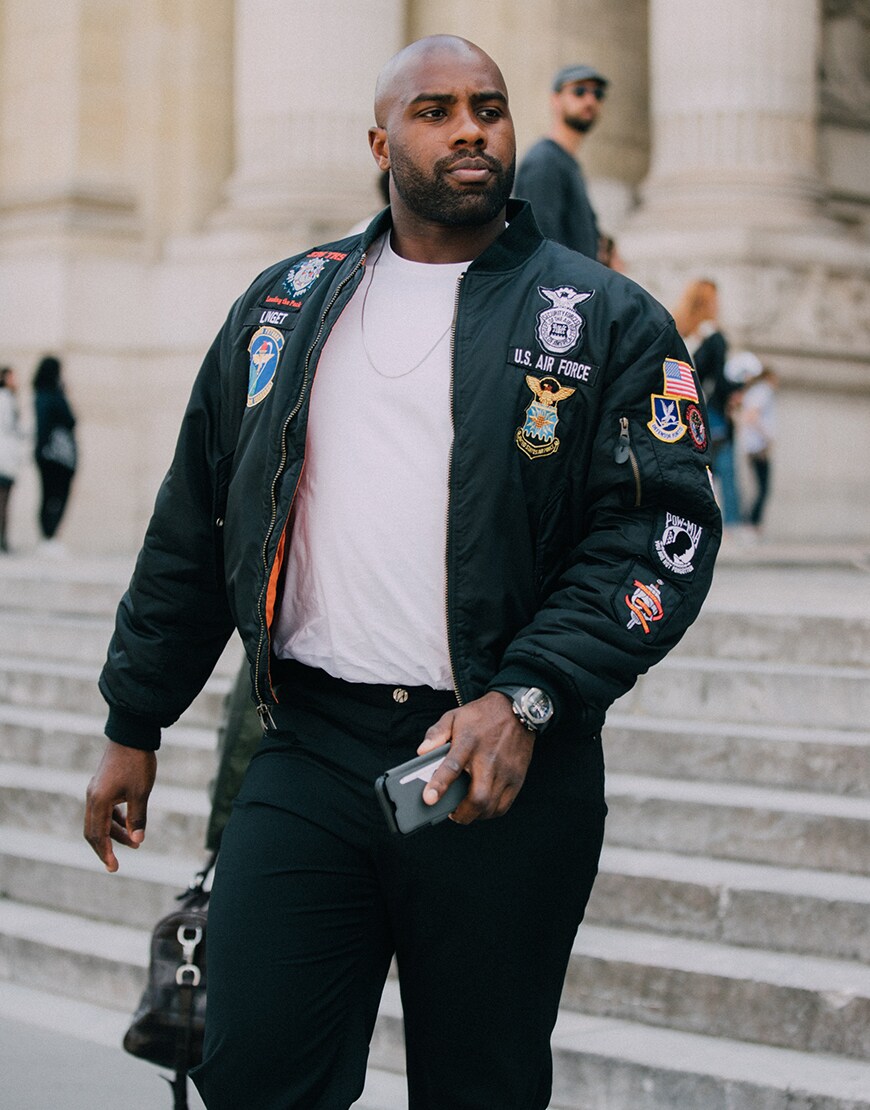 A street-styler wearing a white T-shirt and a bomber jacket at fashion week | ASOS Style Feed