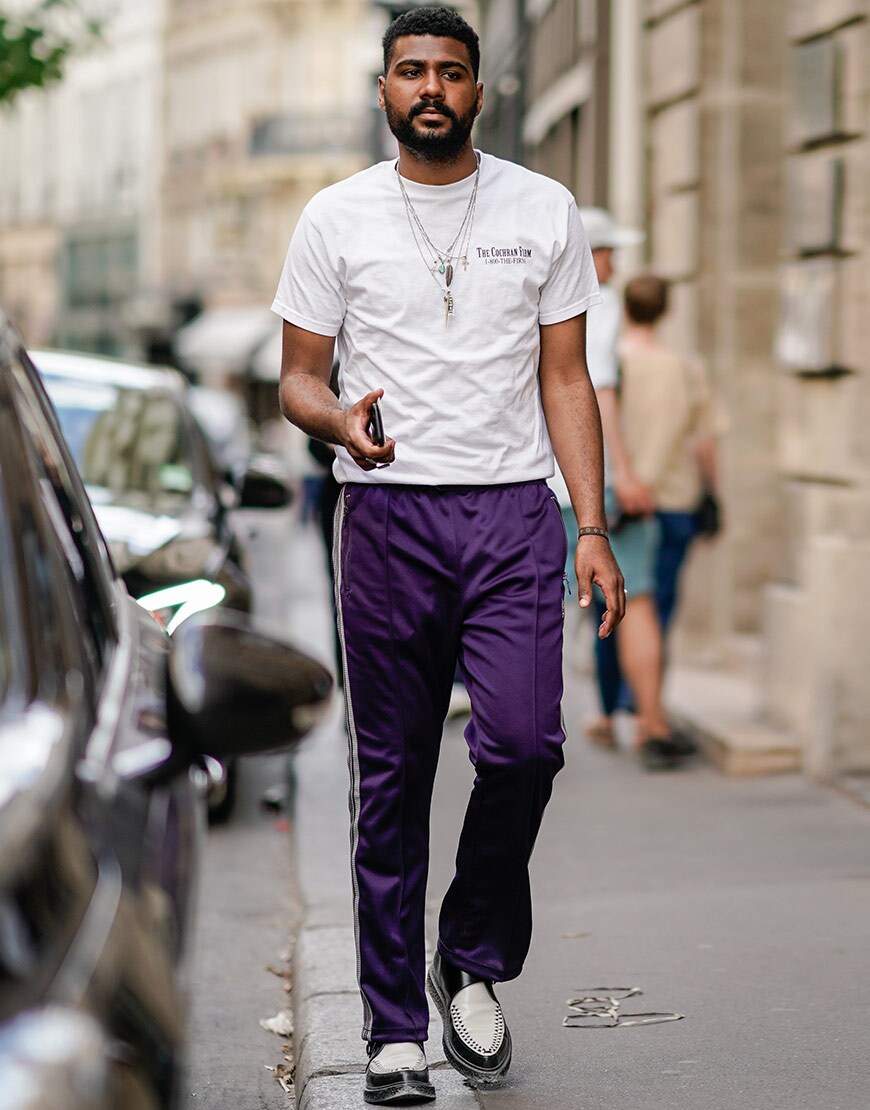 A street-styler wearing a white T-shirt and striped tracksuit bottoms | ASOS Style Feed