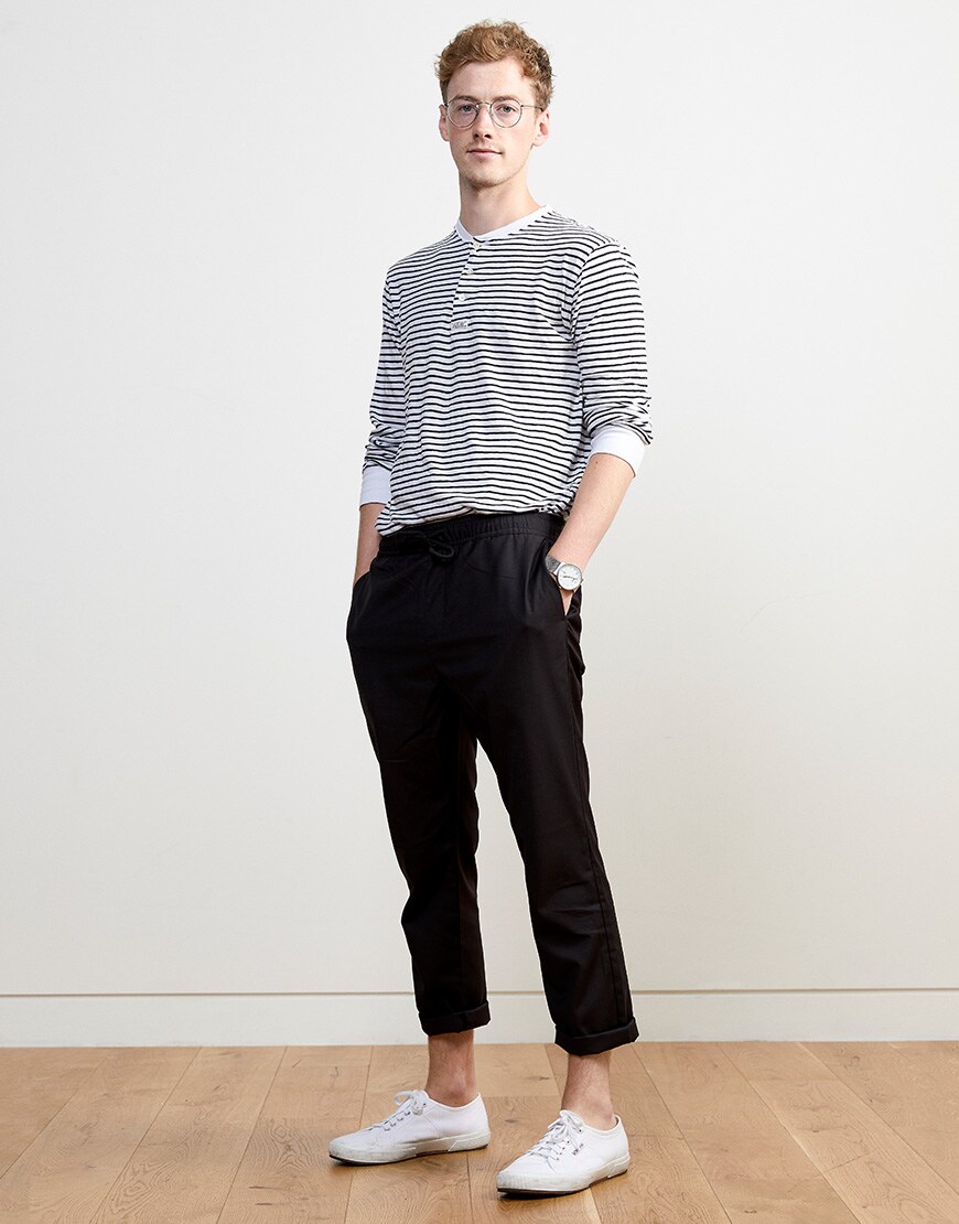 Steven wearing a striped top, glasses, black trousers and white Superga plimsolls | ASOS Style Feed