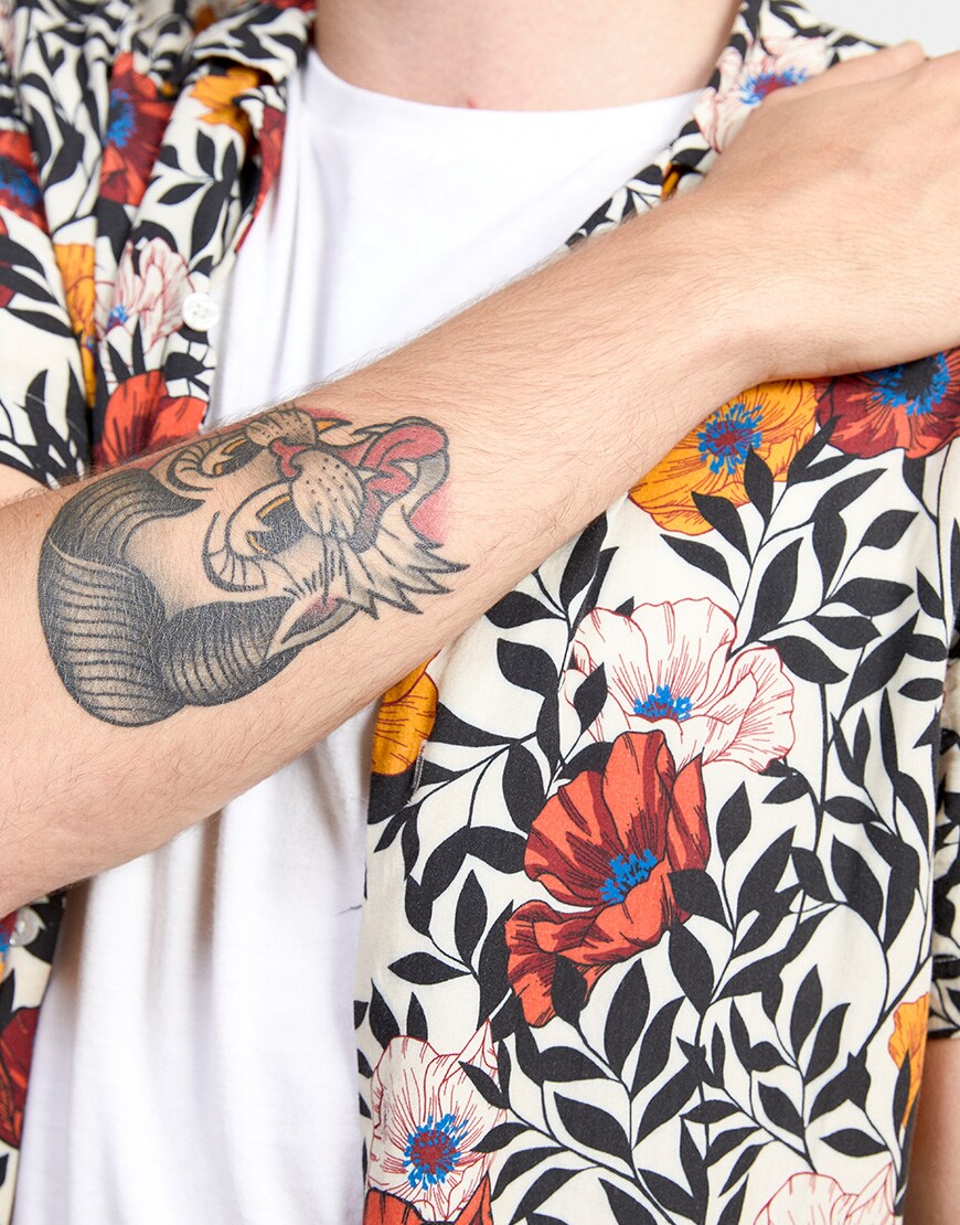 A close-up of Gabriele's white T-shirt and floral-print shirt | ASOS Style Feed