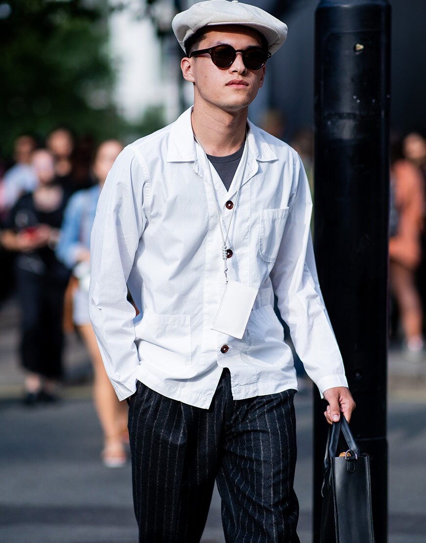 A street-styler wearing a flat cap, shades and a white shacket | ASOS Style Feed