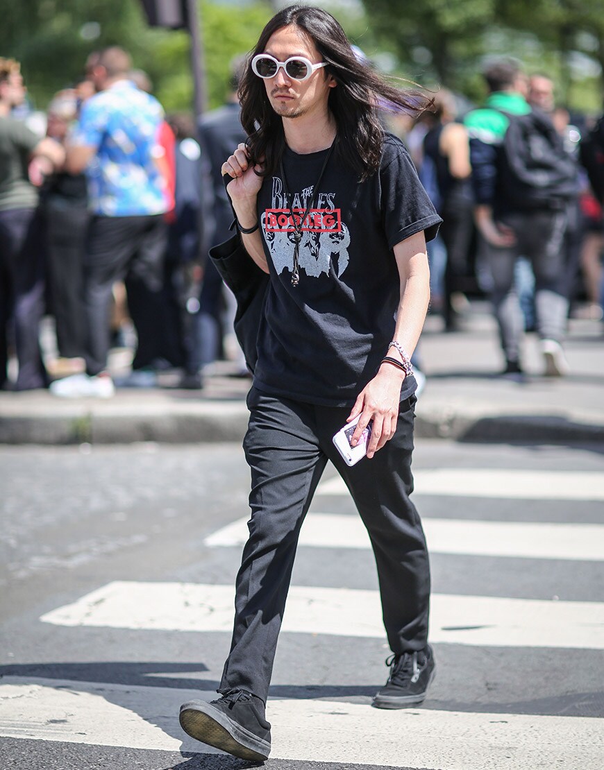 A street-styler wearing a graphic-print T-shirt, black jeans and black Vans trainers | ASOS Style Feed