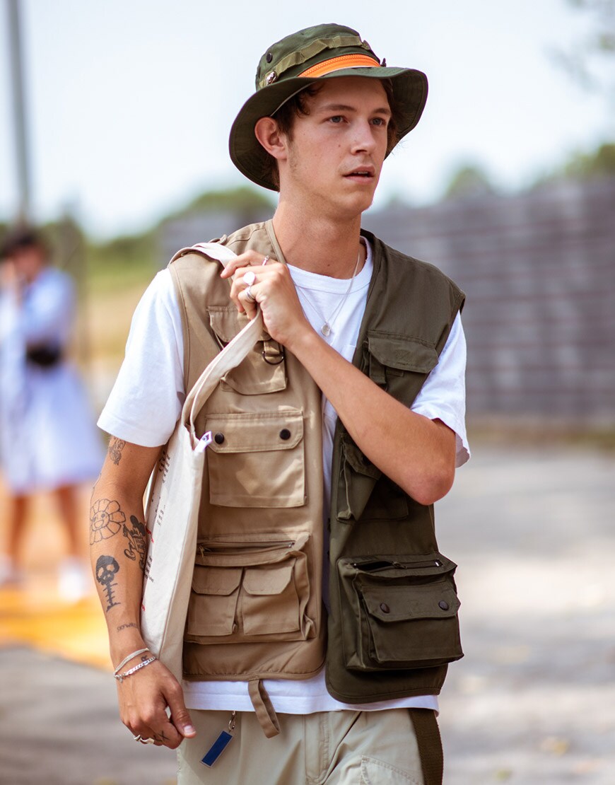 A street-styler wearing a bucket hat, T-shirt and gilet | ASOS Style Feed