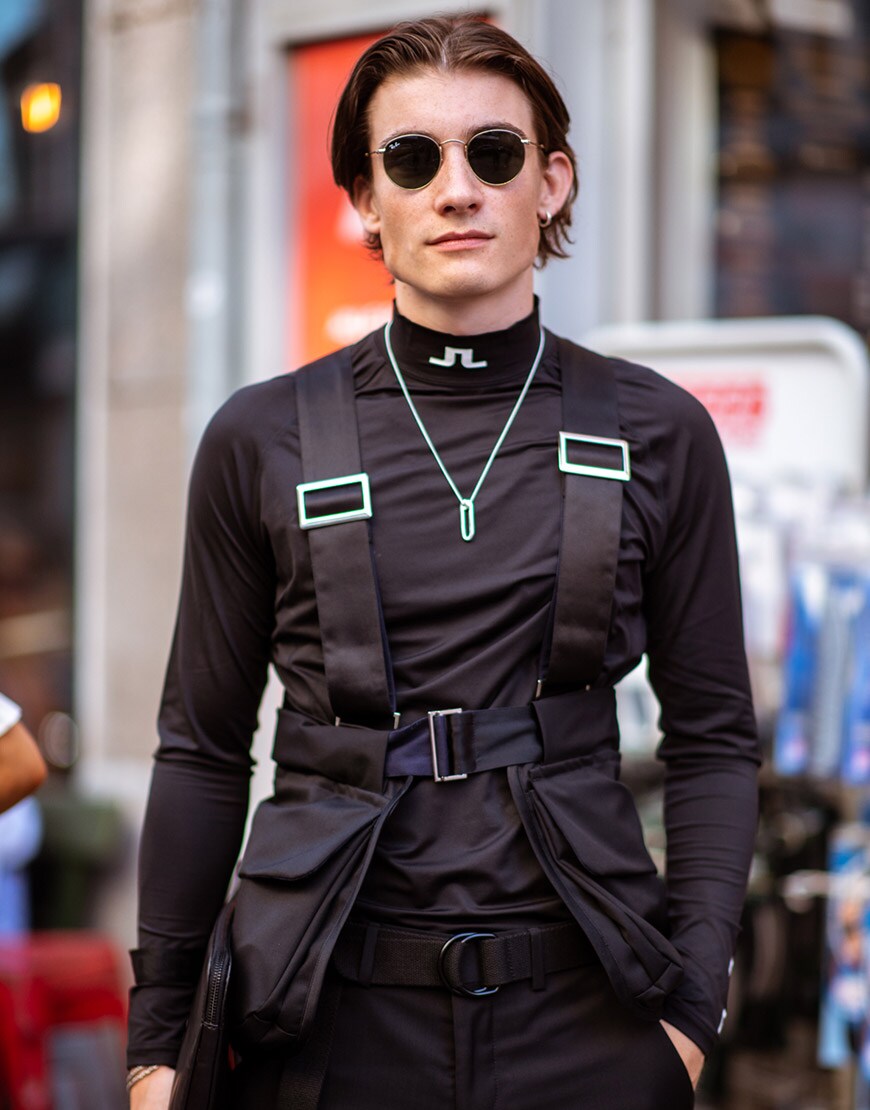 A street-styler wearing an all-black ensemble including shades and a harness | ASOS Style Feed