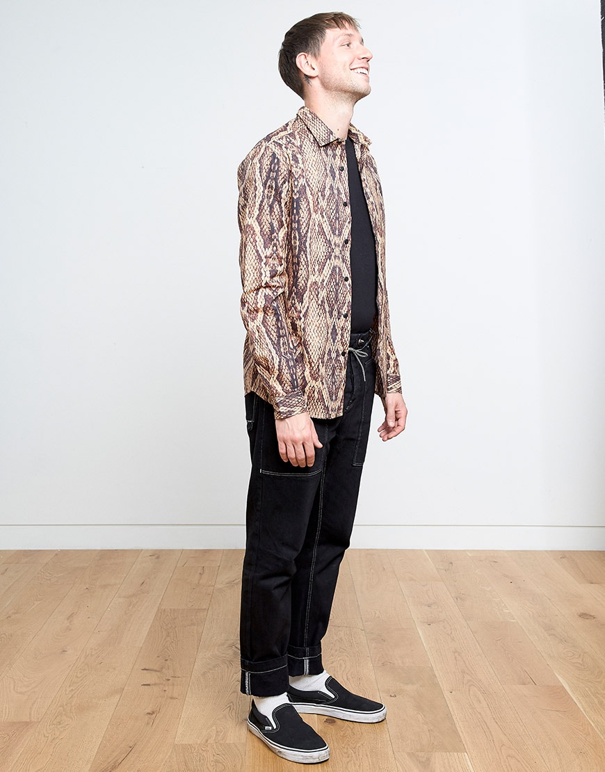 Ben wearing a black T-shirt, black jeans, Vans trainers and a snakeskin-print shirt | ASOS Style Feed