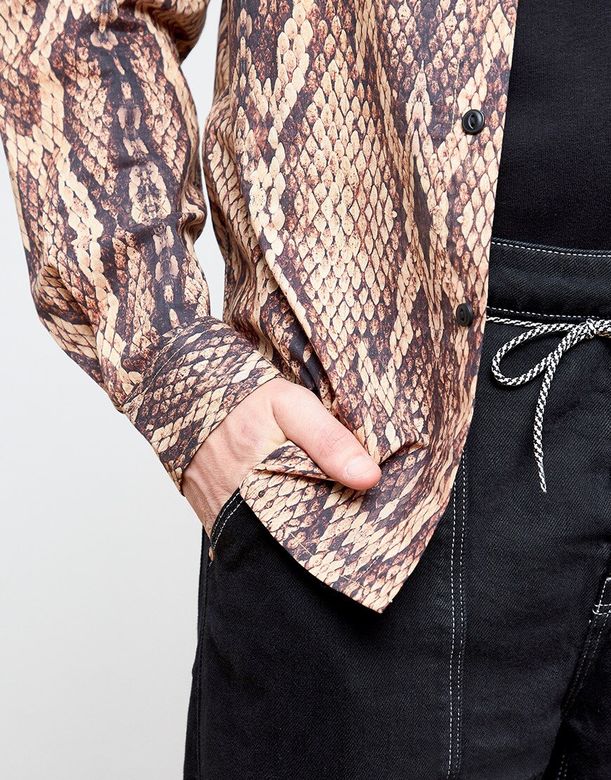 A close-up of Ben wearing a black T-shirt, black jeans and a snakeskin-print shirt | ASOS Style Feed