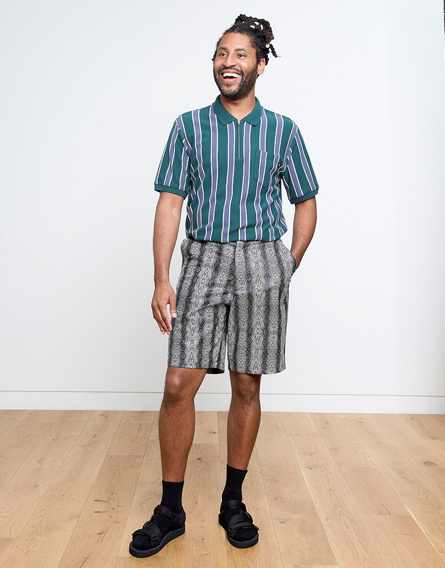 Cobbie wearing a striped polo shirt, snakeskin-print shorts and socks and sandals | ASOS Style Feed