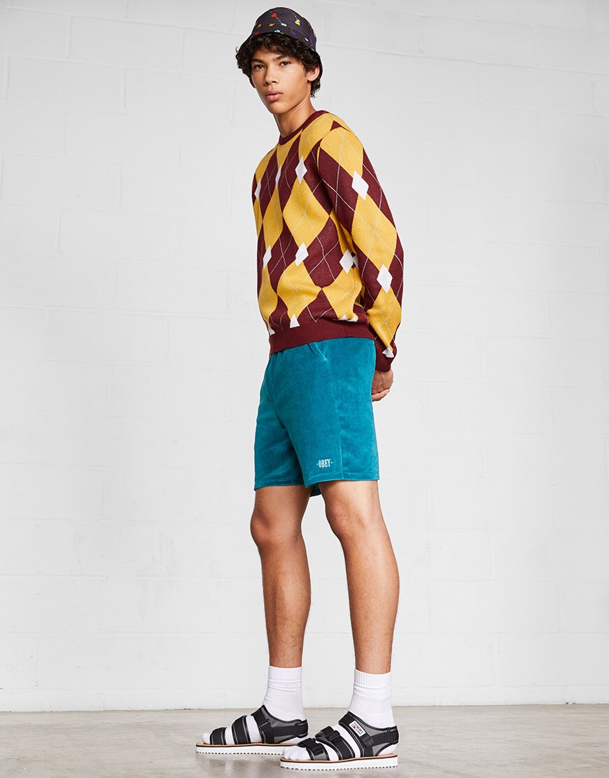 An ASOS model wearing a diamond-knit jumper, bucket hat, Obey shorts and socks and sandals| ASOS Style Feed