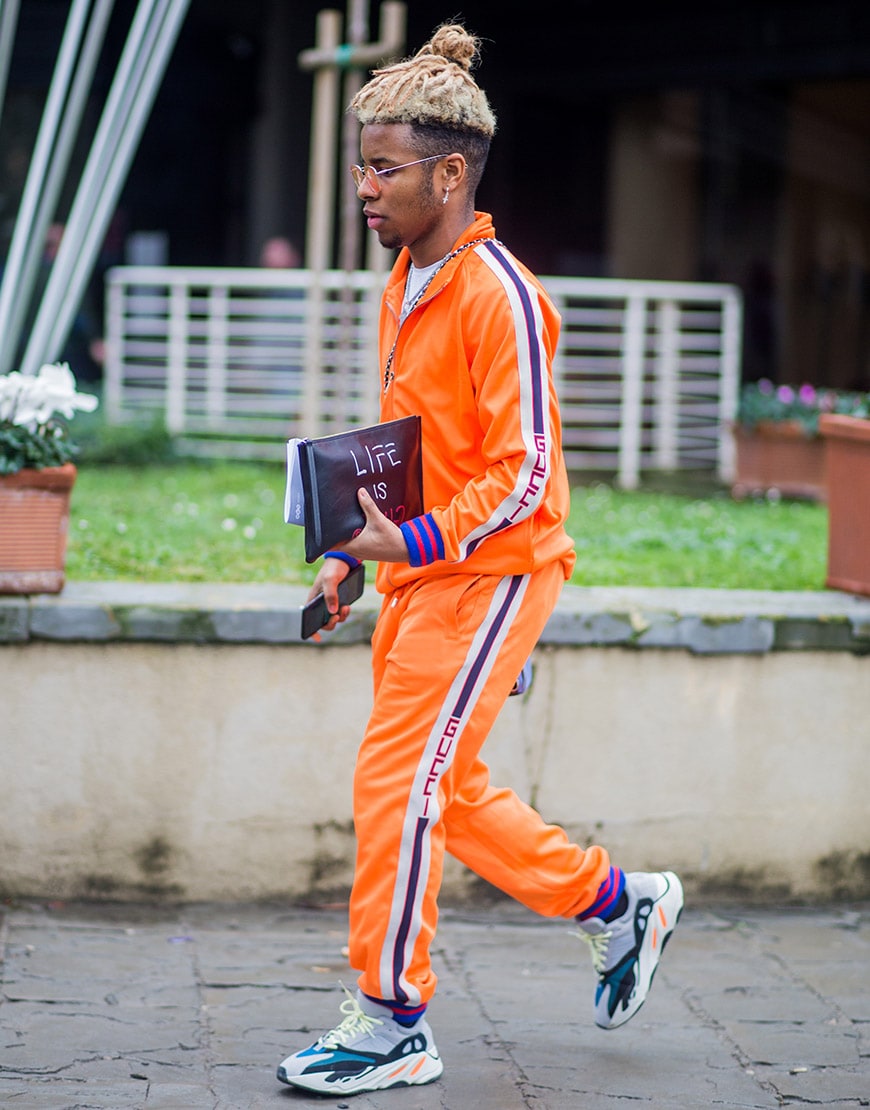 A street-styler wearing an emergency-orange tracksuit and retro shades | ASOS Style Feed