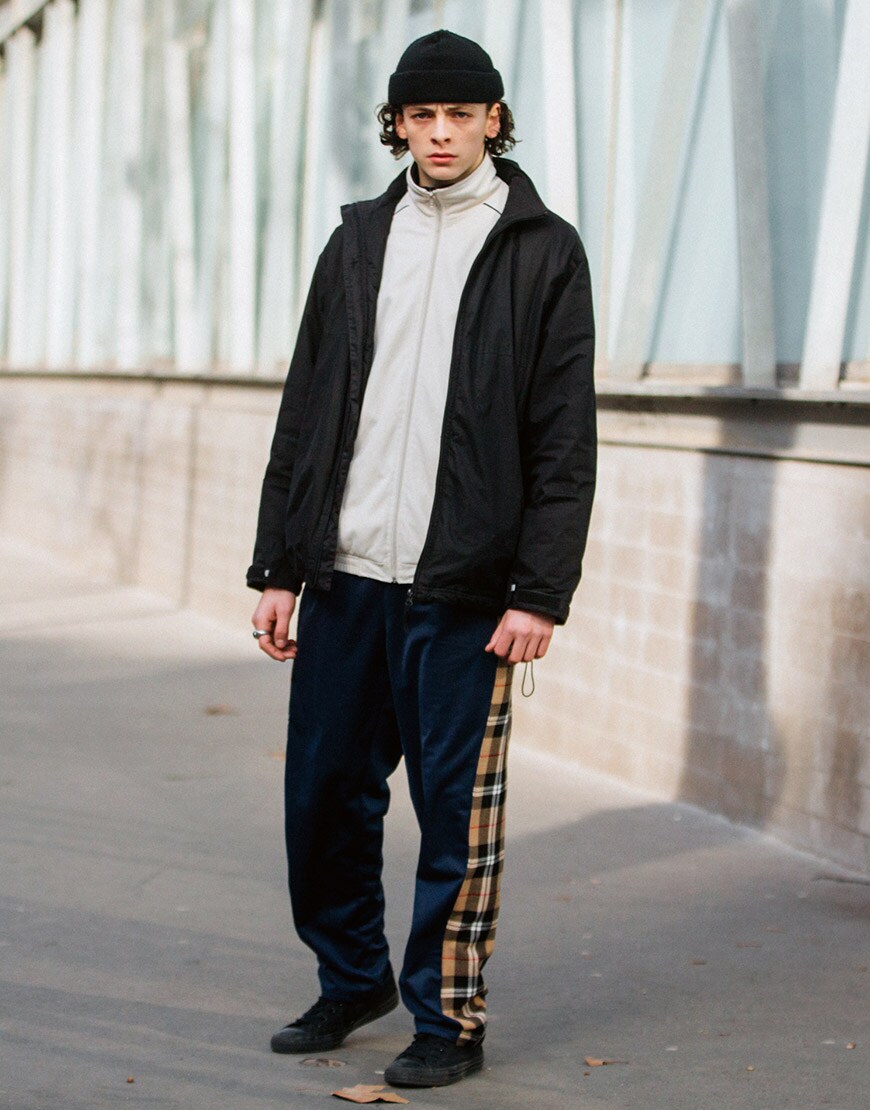A model wearing a track top, beanie, coat, check tracksuit bottoms and trainers | ASOS Style Feed