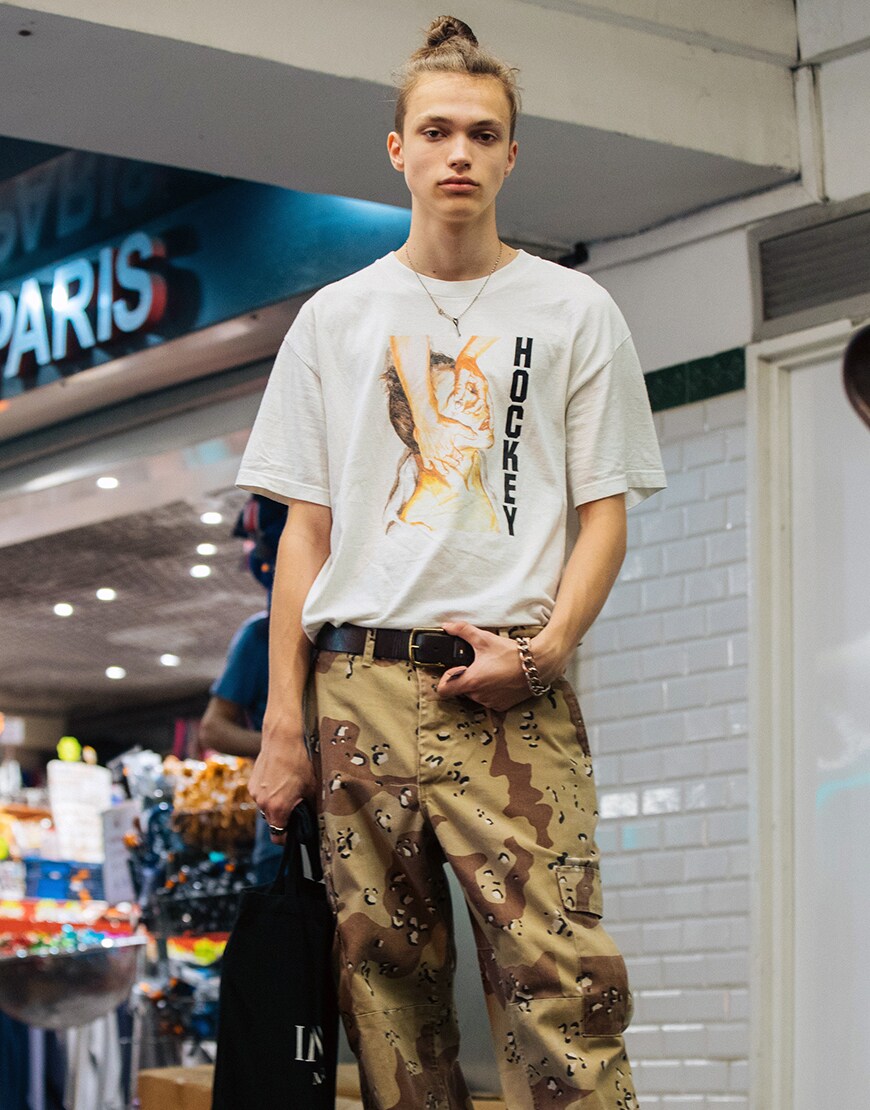 A street-styler wearing a graphic-print T-shirt, cargo trousers, Air Force 1s and a tote bag | ASOS Style Feed