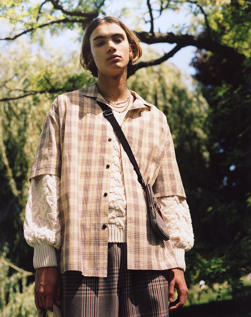 Editorial Bild eines jungen Mannes mit Karohemd und Strickpulli