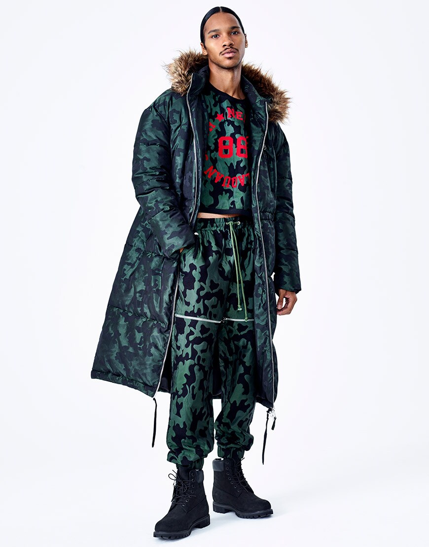 A model wearing a printed co-ord and coat from the ASOS DESIGN x LaQuan Smith range available at ASOS | ASOS Fashion & Beauty Feed