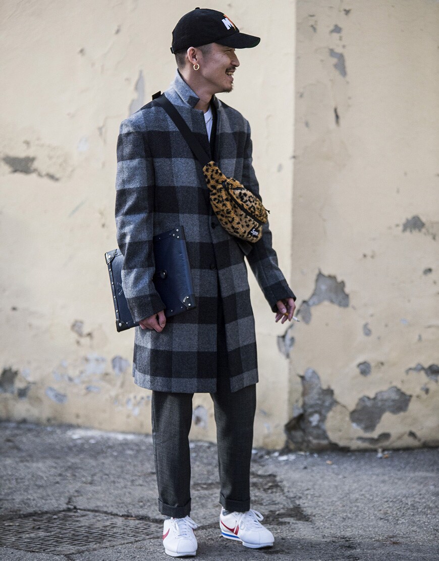 Street style portant un manteau à carreaux et un sac banane en polaire léopard