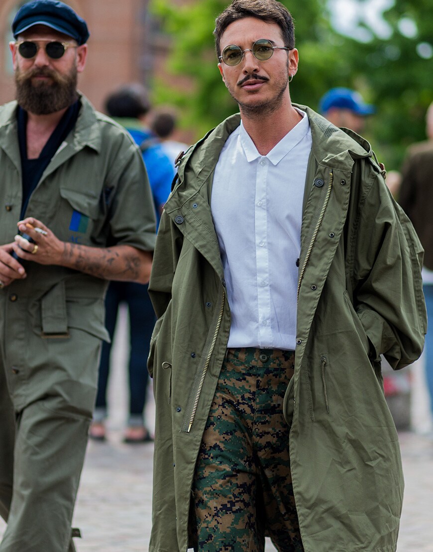 Street styler wearing a white shirt, camo trousers and a khaki parka | ASOS Style Feed