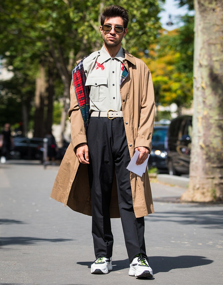 A street-styler wearing a printed shirt, a trench coat, trousers and chunky trainers | ASOS Style Feed