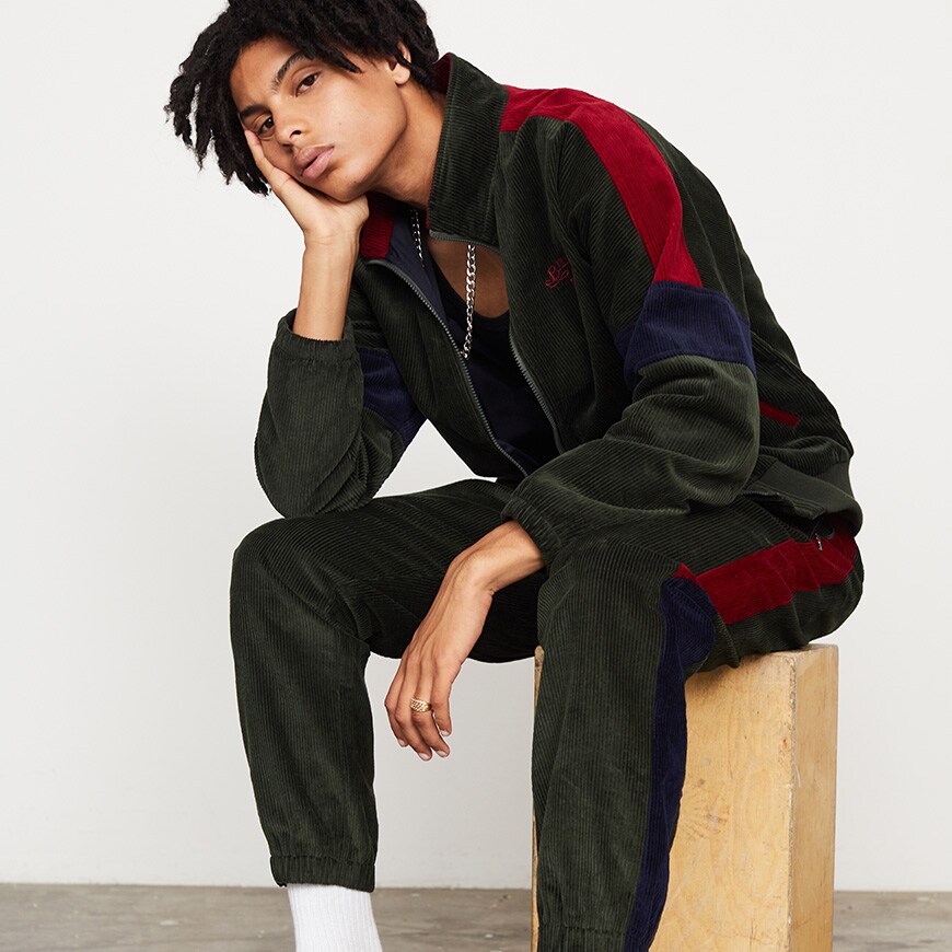 A model wearing a multi-coloured Billionaire Boys Club tracksuit with a black vest | ASOS Style Feed
