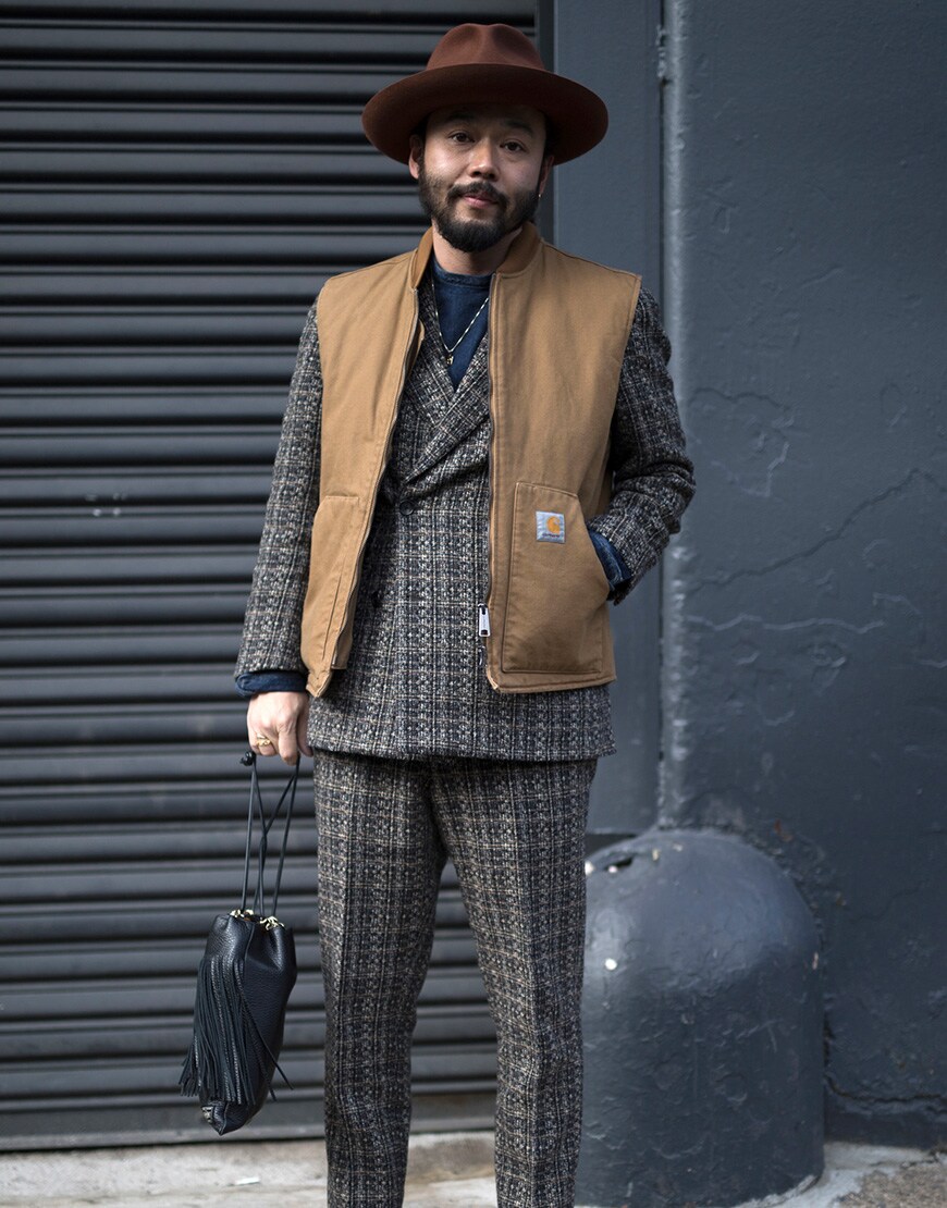 A stylish guy in a Carhartt WIP gilet over a three piece suit