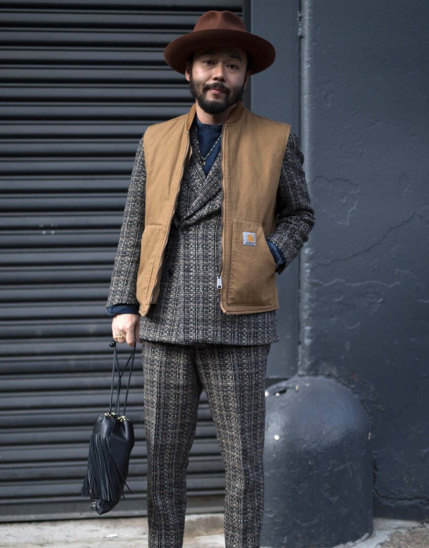 A stylish guy in a Carhartt WIP gilet over a three piece suit