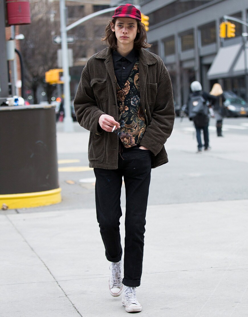 A street-styler wearing a cord jacket, shirt, jeans, Converse sneakers and a check hat | ASOS Style Feed