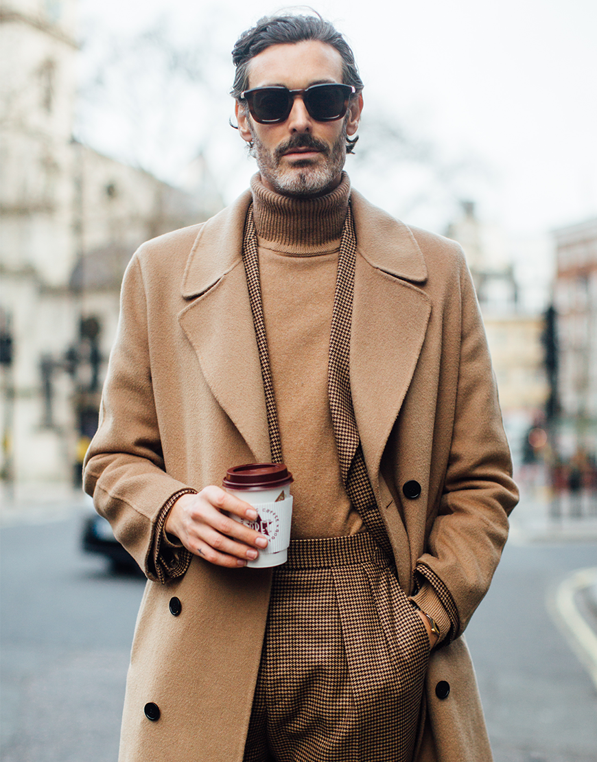 A picture of a streetstyler wearing a camel roll neck, a check suit and matching wool overcoat