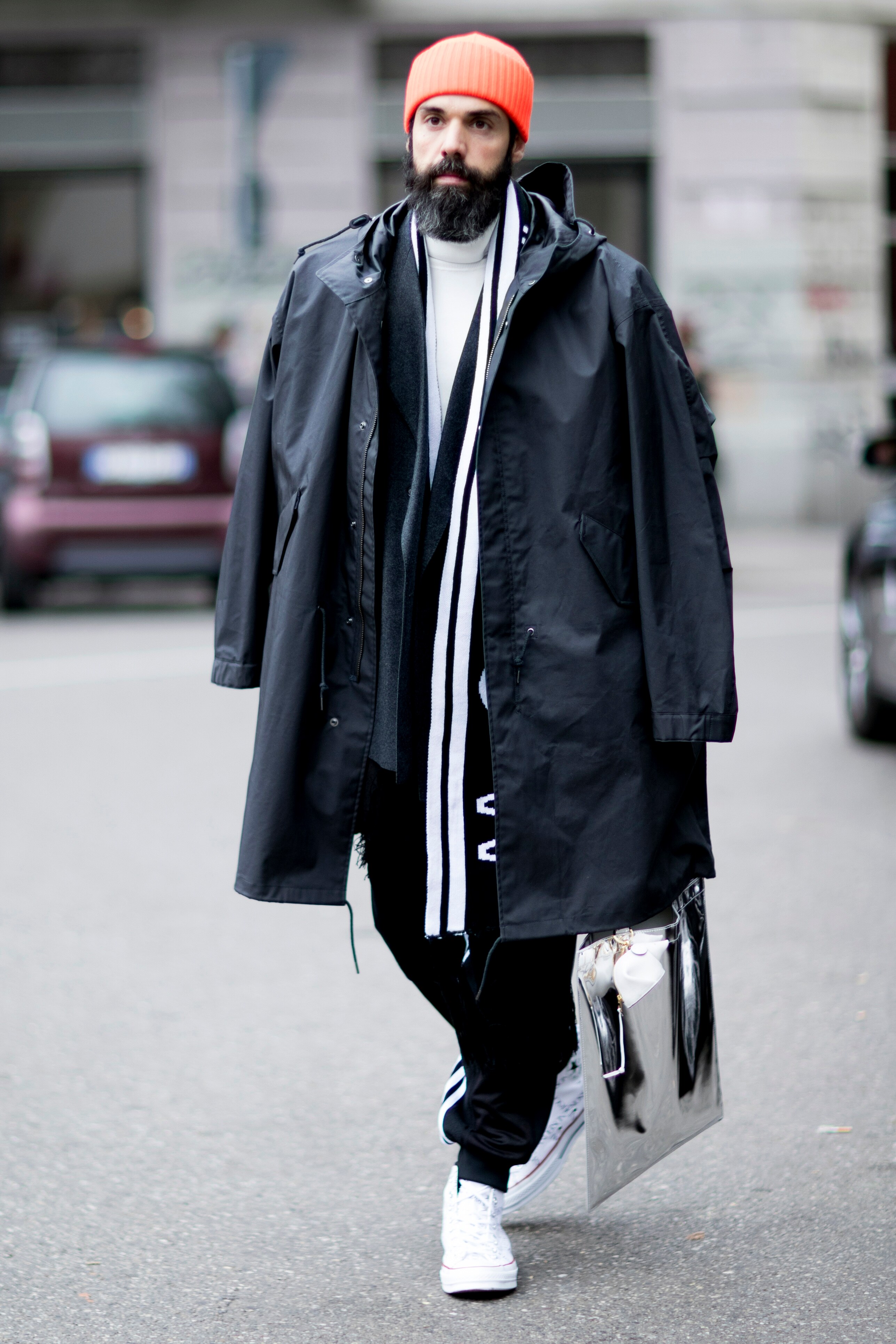 A picture of a streetstyler wearing a white roll neck underneath a layered jacket and coat. 