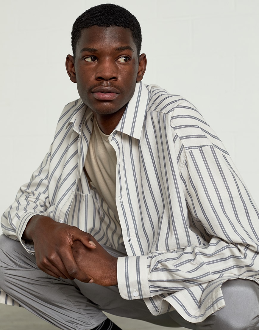 A picture of a model wearing an ASOS White outfit including a striped shirt, technical joggers and Nike trainers. Available at ASOS
