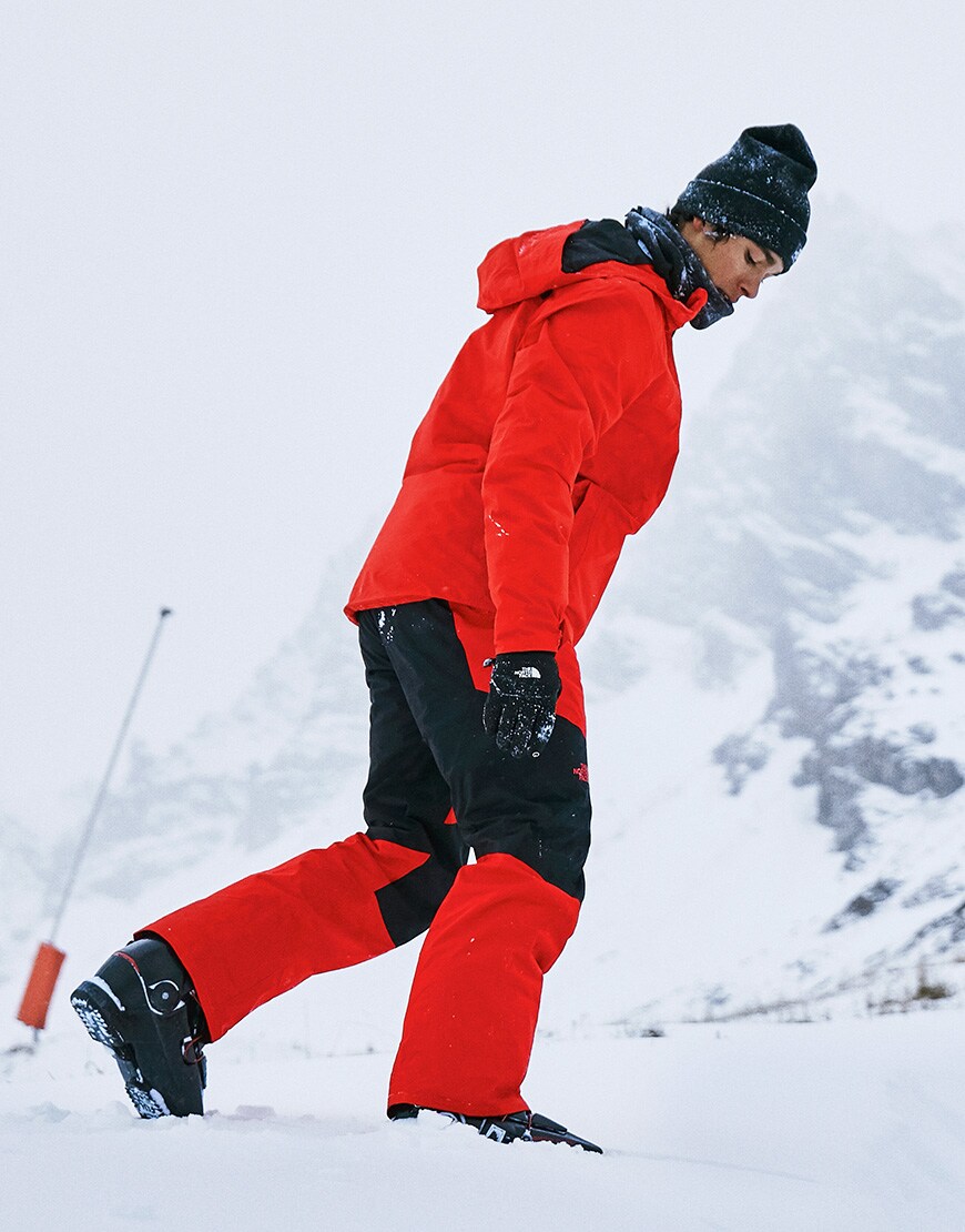 A picture of a man wearing a ski jacket and ski pants by The North Face. Both available on ASOS.