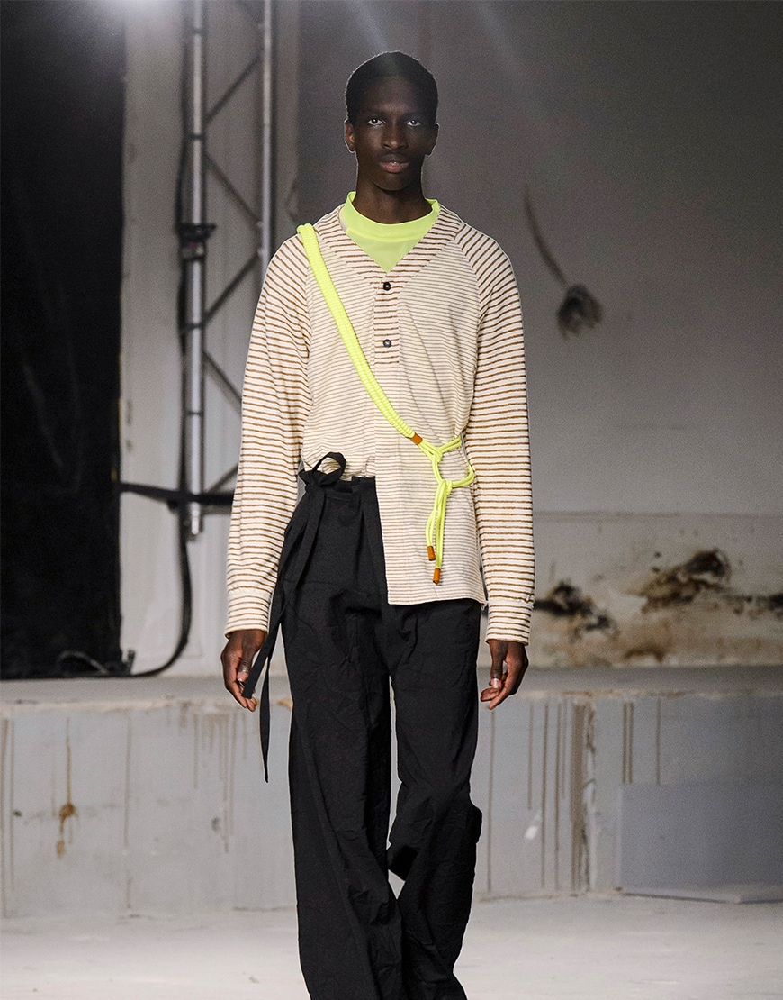 A picture of a catwalk model wearing a Gucci jumper, neon T-shirt and wide-leg trousers.